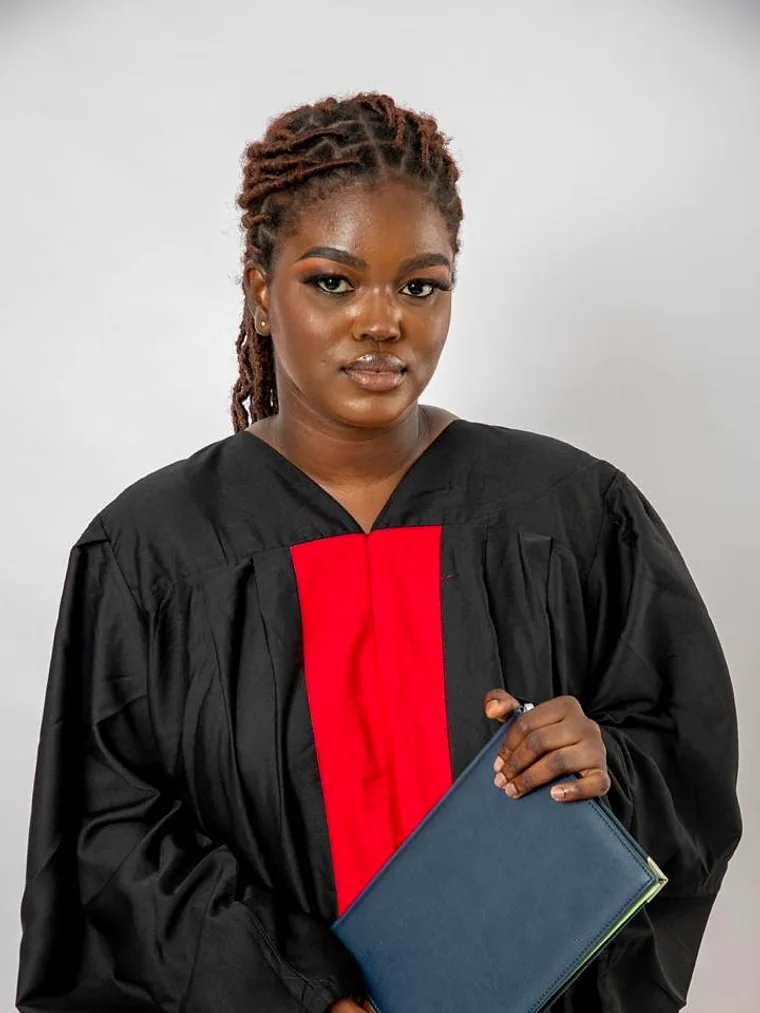 Portrait d'une diplômée en toge, son parchemin à la main